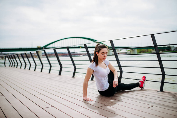 Young woman practicing yoga in city quay - Zdjęcie, obraz