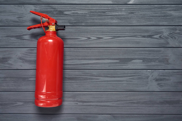 Fire extinguisher on wooden planks - Foto, afbeelding