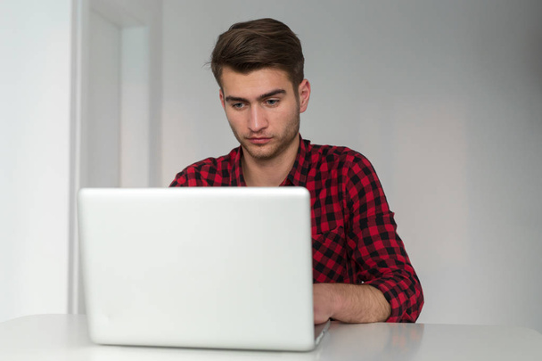 Young Businessman working at home in plaid shirt - Fotó, kép