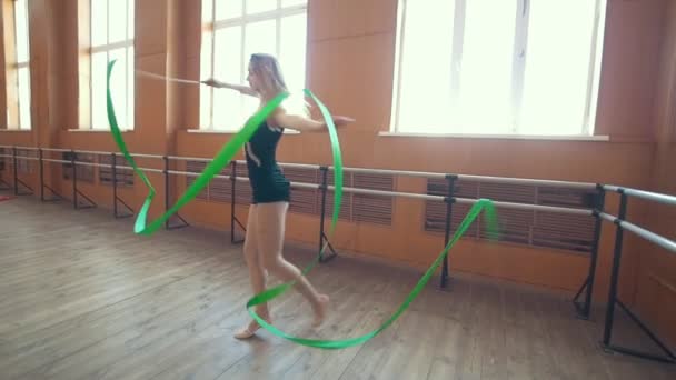 Gymnastiek - jonge vrouw dansen met een groen lint - opleiding een gymnastiek-oefening, slow-motion - Video