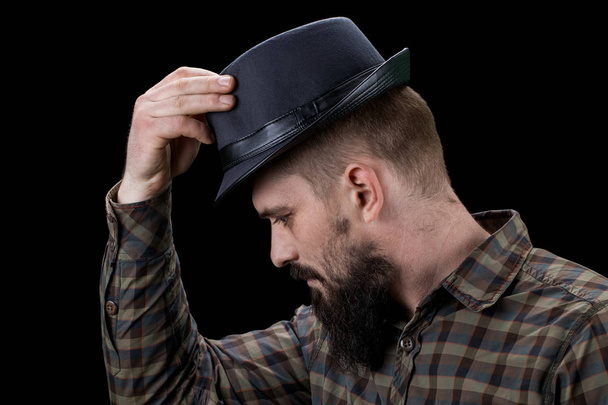 Side view of sad bearded man with hat looking down - Photo, Image