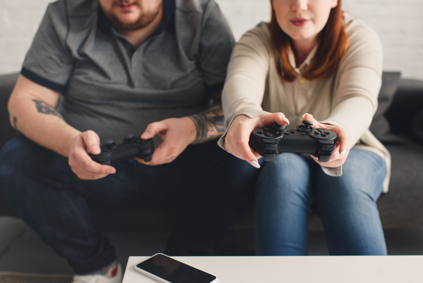 imagem cortada de namorado e namorada jogando videogame em casa
 - Foto, Imagem