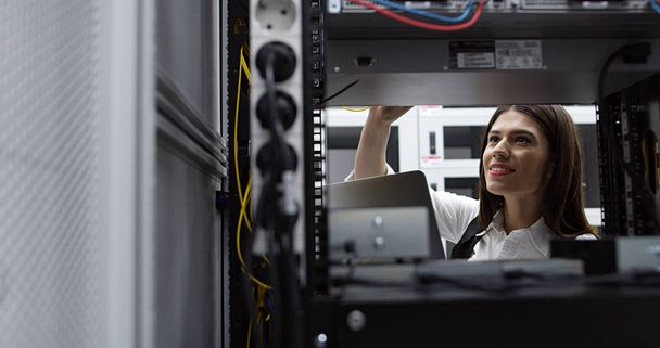 Technician performing maintenance tasks in a server room rack - Foto, imagen