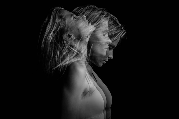 Beautiful phantom mystical mysterious ambiguous original conceptual profile side portrait of young blonde woman on a black background. Black and white photo. triple exposure. - 写真・画像