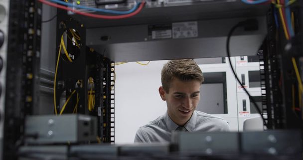 Technician performing maintenance tasks in a server room rack - Foto, Imagem
