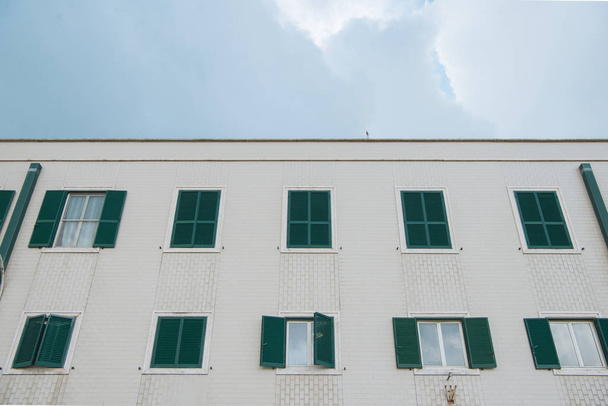 vista inferior del edificio europeo con ventanas cerradas frente al cielo nublado, Anzio, Italia
 - Foto, imagen