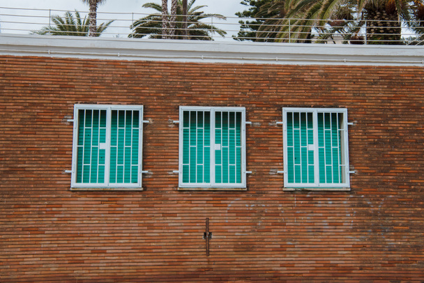 πρόσοψη του κτιρίου, με παράθυρα με παντζούρια μπροστά από φοίνικες, Anzio, Ιταλία - Φωτογραφία, εικόνα