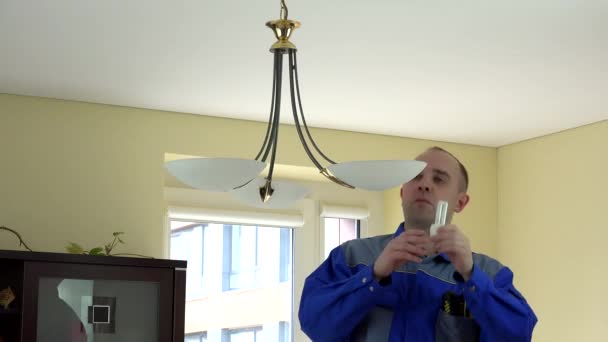 Electricista experimentado cambiando bombillas en el hogar del cliente
. - Imágenes, Vídeo