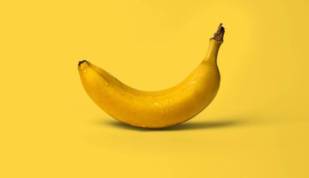 Свіжі стиглі мокрі бананові фрукти краплі води на жовтому фоні
 - Фото, зображення