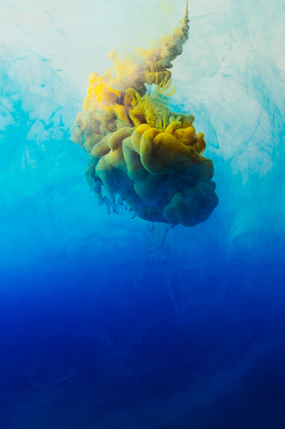 lähikuva sinisten, turkoosien ja keltaisten maalien sekoittumisesta veteen
 - Valokuva, kuva