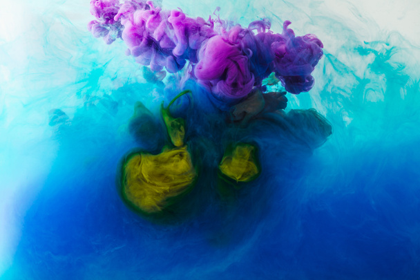 full frame image of mixing of blue, turquoise, yellow and purple paints splashes  in water - Photo, Image
