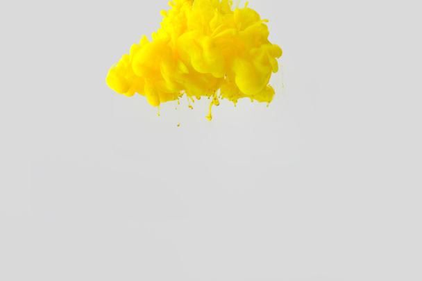 close up view of bright yellow paint splash in water isolated on gray - Photo, Image