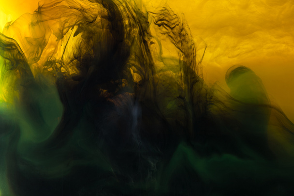 imagen de marco completo de mezcla de pinturas amarillas, verdes y negras salpicaduras en el agua
 - Foto, Imagen
