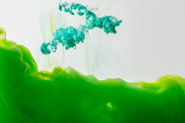 close up view of mixing of green and bright turquoise paints splashes in water isolated on gray - Fotoğraf, Görsel