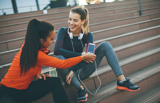 Due giovani attraente corridore femminile prendendo pausa dopo aver fatto jogging all'aperto
 - Foto, immagini