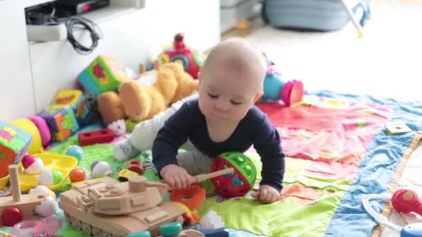 Χαριτωμένο μικρό παιδί μωρό αγόρι, παίζει στο σπίτι στο πάτωμα στην κρεβατοκάμαρα, χαμογελώντας ευτυχώς - Πλάνα, βίντεο