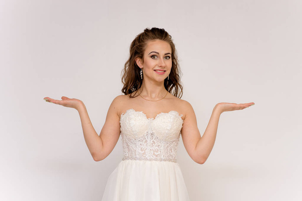 beautiful bride in white wedding dress in different poses on white backgrounds shows different emotions - Foto, Imagem