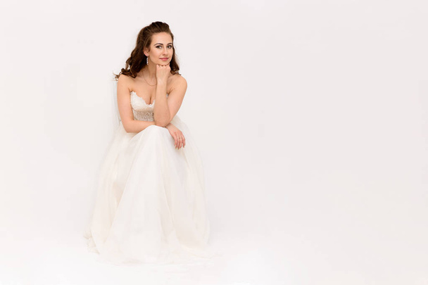 beautiful bride in white wedding dress in different poses on white backgrounds shows different emotions - Foto, Imagem