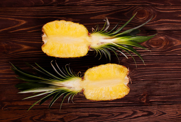 Pineapple halves over wooden background - Fotoğraf, Görsel