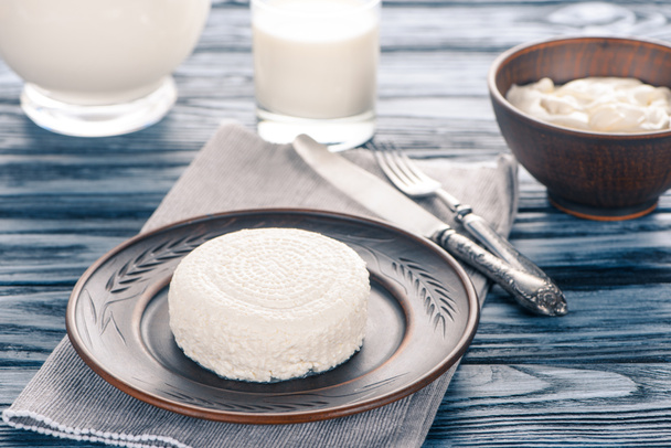 свіжий здоровий сир на тарілці, сметані та склянці молока на дерев'яному столі
 - Фото, зображення