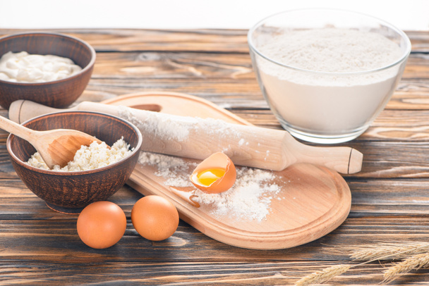 close-up view of cottage cheese, eggs and flour on wooden table   - Photo, Image