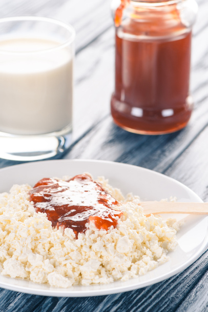 close-up view of healthy cottage cheese with jam and glass of milk on table  - Foto, immagini