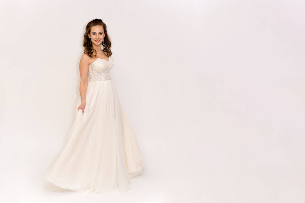 beautiful bride in white wedding dress in different poses on white backgrounds shows different emotions - Foto, imagen