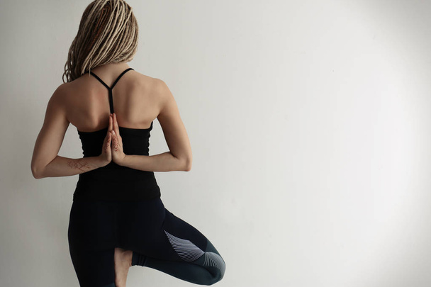 Mujer joven practicando yoga sobre fondo claro
 - Foto, imagen