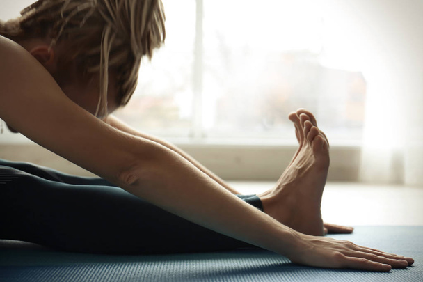Young woman practicing yoga indoors - Φωτογραφία, εικόνα