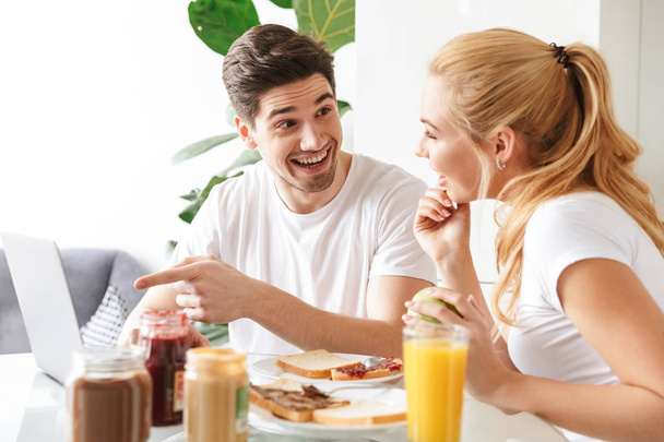 Cute cheerful young loving couple have a breakfast - Foto, imagen