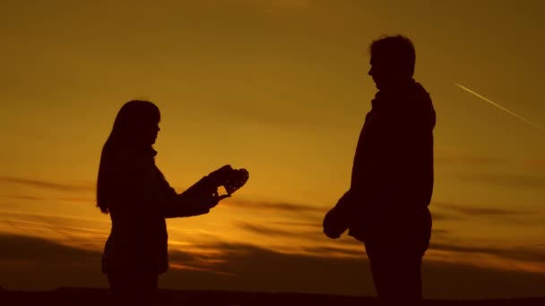 Mädchen schenkt Mann bei Sonnenuntergang ihr Herz. - Filmmaterial, Video