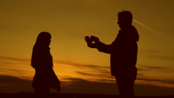 Papa schenkt Mädchen bei Sonnenuntergang sein Herz. - Filmmaterial, Video