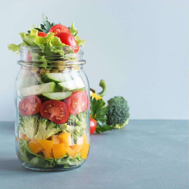 Healthy homemade vegetable salad in mason jar with tomato, lettuce, broccoli. Copy space. Lunch for work. - Fotoğraf, Görsel