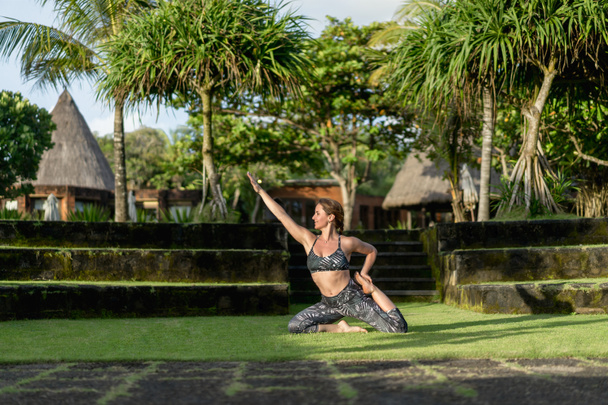 женщина практикует йогу с красивыми зелеными растениями на заднем плане, Бали, Индонезия
 - Фото, изображение