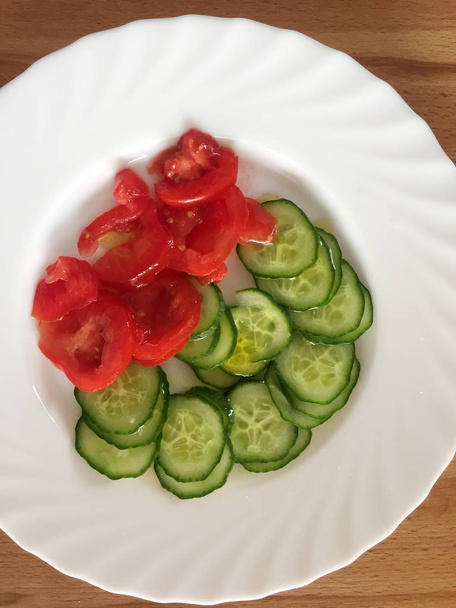 Cucumber tomato salad on the white plate - Zdjęcie, obraz