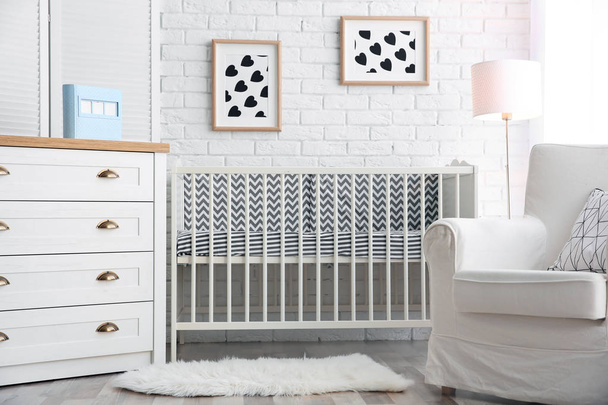 Modern interior of light cozy baby room with crib - Фото, изображение