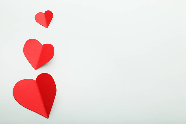Red paper hearts on grey background - 写真・画像