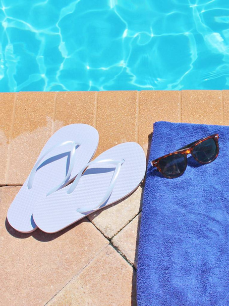 プールサイドプールタオルビーチシューズスイミングプール夏休み休暇風光明媚なサングラスとトンの靴フリップフロップ在庫、写真、写真, - 写真・画像