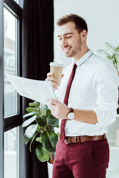 pohledný podnikatel s kávou, čtení novin v moderní kanceláři - Fotografie, Obrázek
