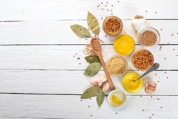 Assortment of mustard in sauces. Spices On a white wooden background. Top view. Copy space for your text. - Fotografie, Obrázek