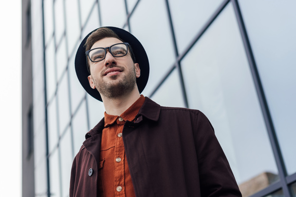 bottom view of handsome stylish man posing in glasses and trendy hat   - Photo, image
