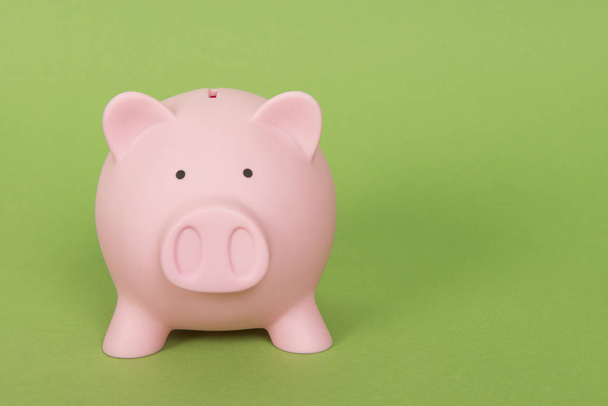 Piggy bank rosa em um fundo verde
 - Foto, Imagem