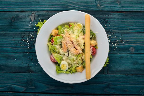Chicken Salad and Fresh Vegetables. Caesar. Top view. On a blue wooden background. Copy space. - Photo, Image