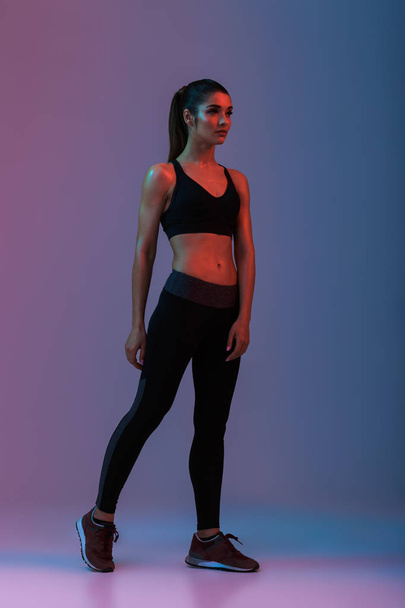 Full length portrait of sportswoman in fitness clothing looking  - Foto, afbeelding