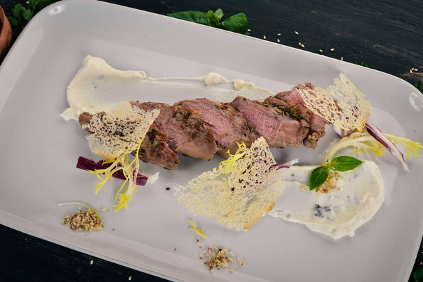 Baked veal with sour cream sauce. Top view. On a wooden background. Copy space. - Valokuva, kuva