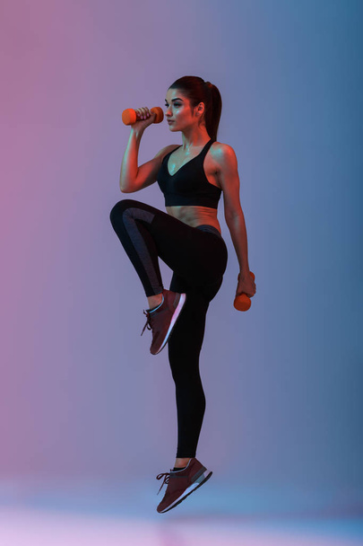 Full length portrait of sportswoman in tracksuit doing exercises - Foto, Imagem