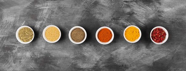 Various spices in bowls on black background. Top view. Food back - Valokuva, kuva