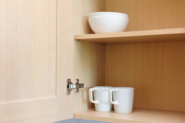 Different white dishes in cupboard in the kitchen. Scandinavian style. - Fotó, kép
