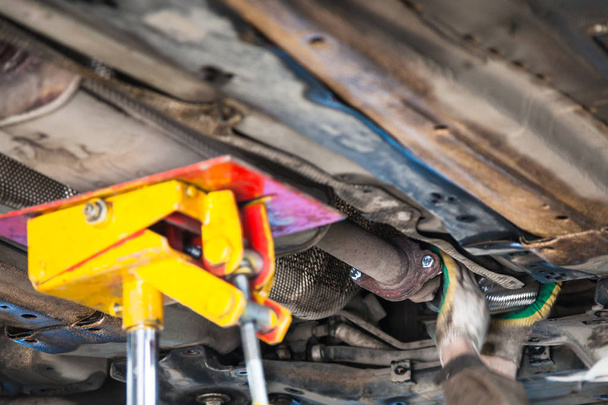 mechanic fixes silencer pipe on car - Photo, Image