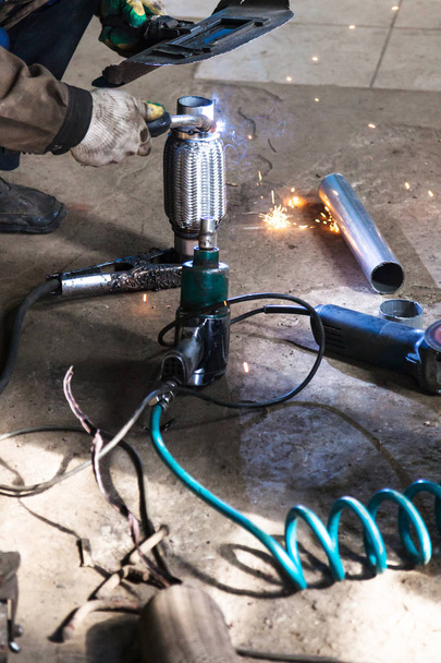 svářeč opravuje potrubí na zvlnění tlumiče - Fotografie, Obrázek